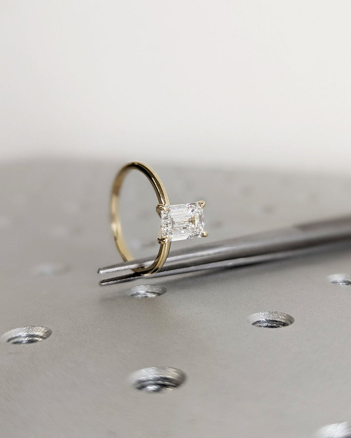 Lifestyle shot of emerald solitaire diamond ring on hand