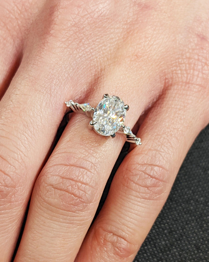 Oval cluster ring set with an IGI graded diamond