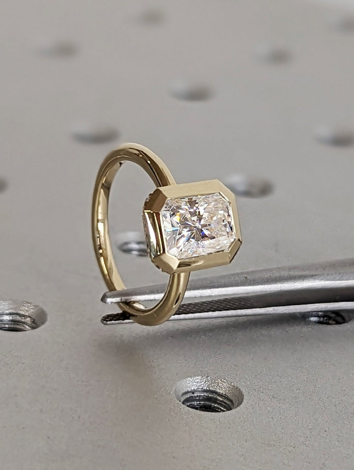 Radiant hidden halo engagement ring photographed in natural light