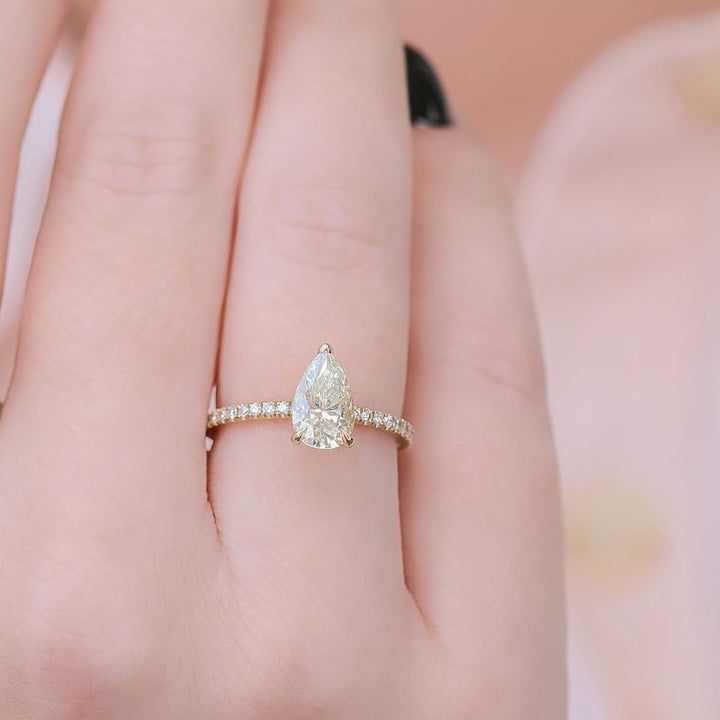 Pear hidden halo engagement ring shown on hand for true-to-life sizing