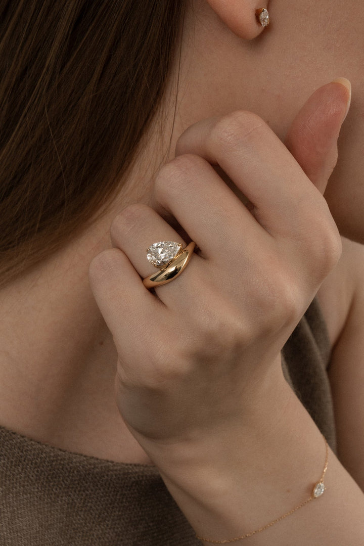 Certified pear cut diamond featured in dome engagement ring