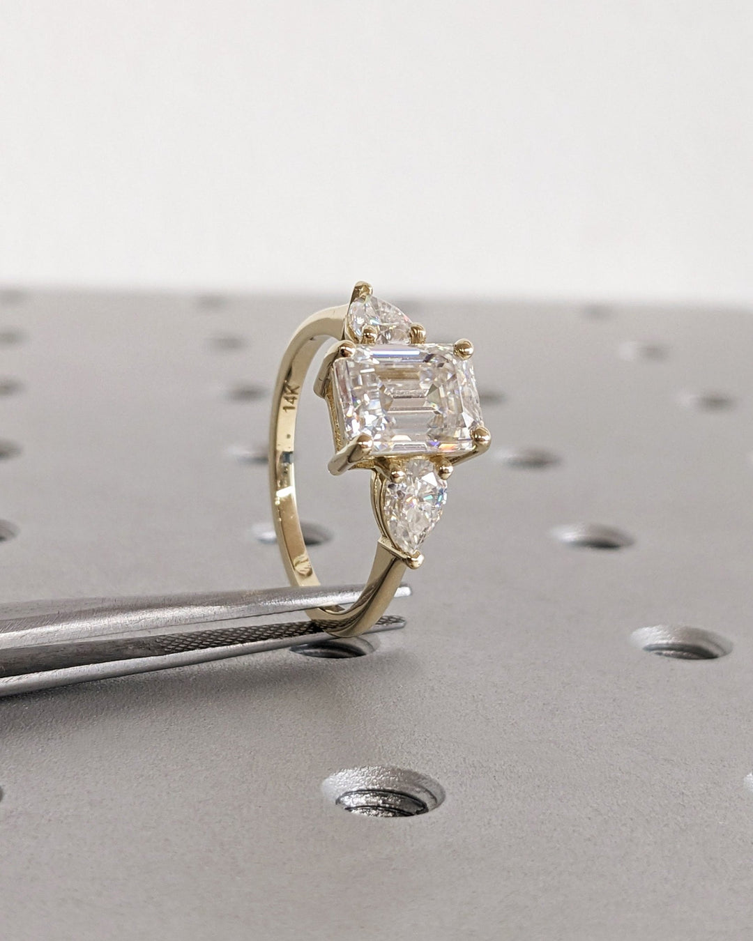 Side angle of emerald three stone diamond engagement ring