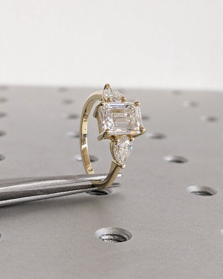 Side angle of emerald three stone diamond engagement ring