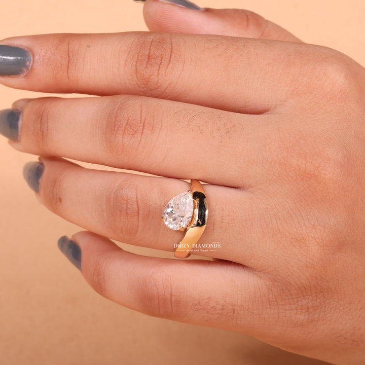 Lifestyle shot of pear east west diamond ring on hand