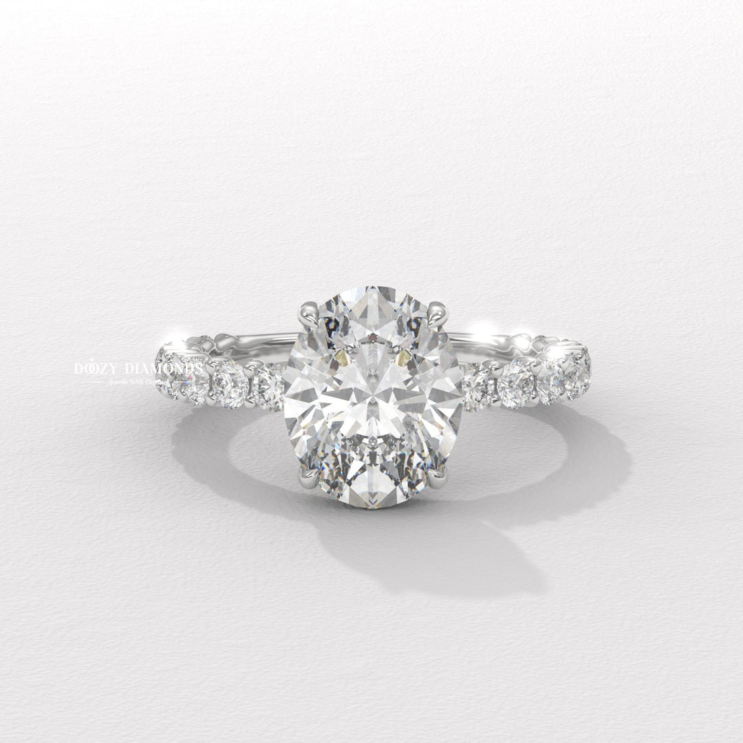 Close-up of oval cut center diamond in pave engagement ring