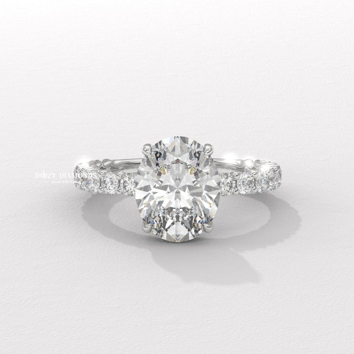 Close-up of oval cut center diamond in pave engagement ring