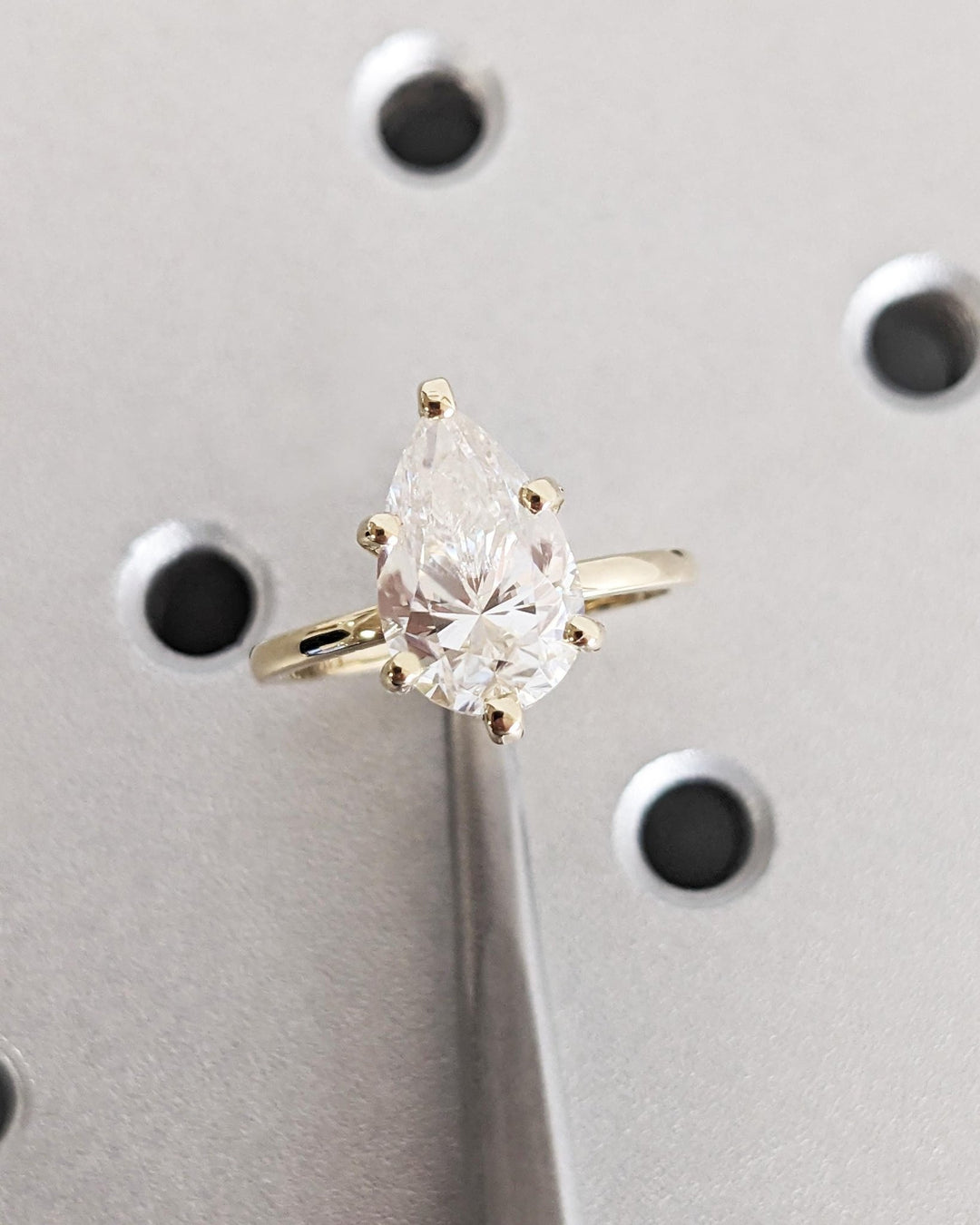 Pear cut engagement ring shown with authenticity certificate