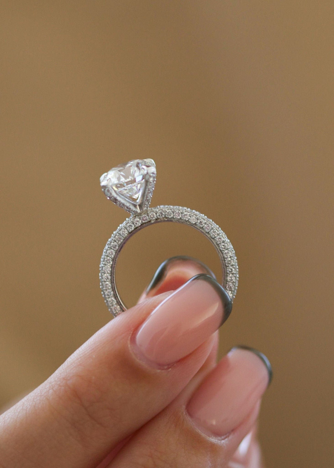 Certified round cut diamond featured in pave engagement ring