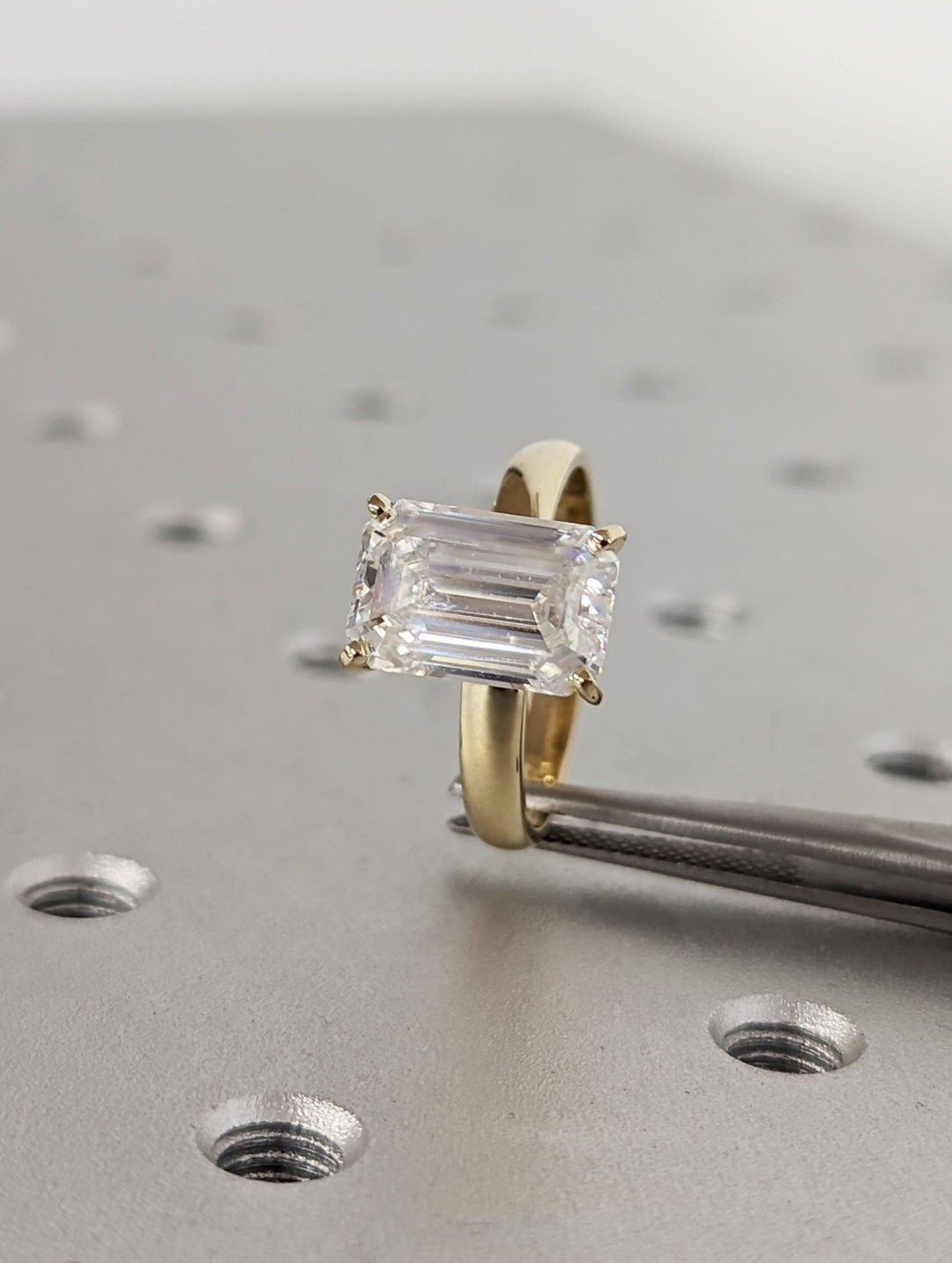 Detailed close-up of emerald solitaire diamond engagement ring