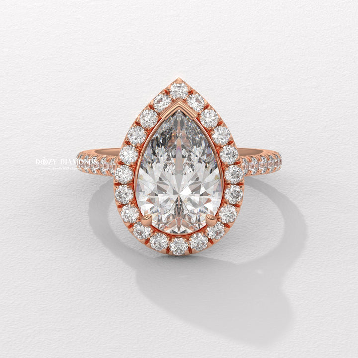 Close-up of pear cut center diamond in halo engagement ring