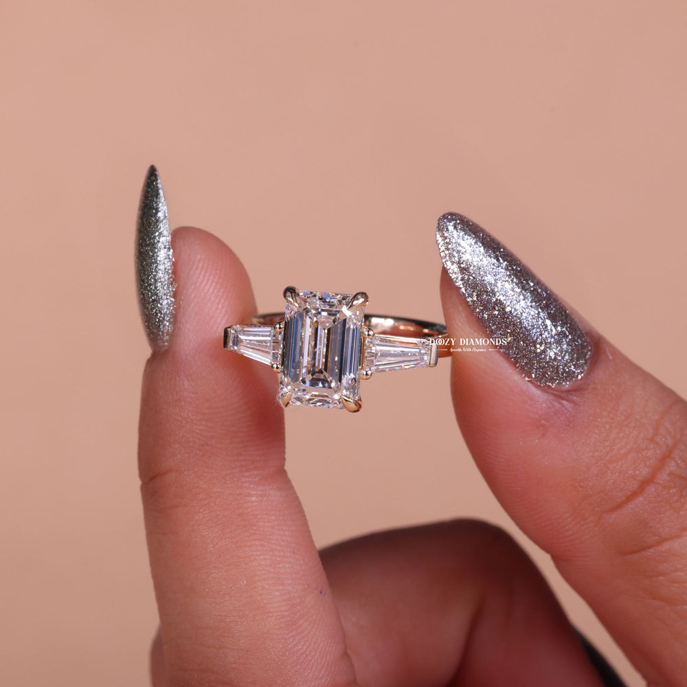 Emerald three stone engagement ring shown on hand for true-to-life sizing