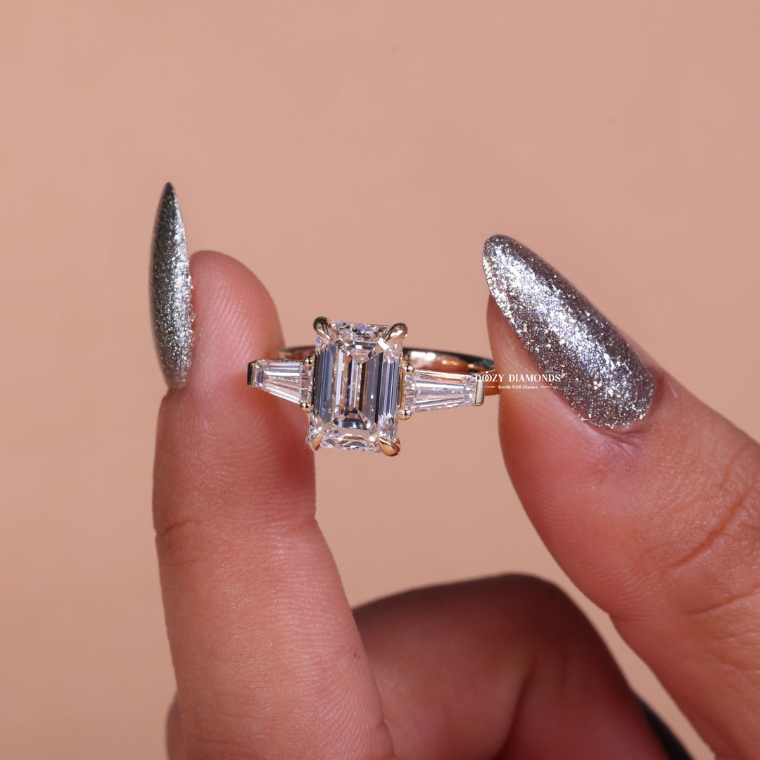 Emerald three stone engagement ring shown on hand for true-to-life sizing