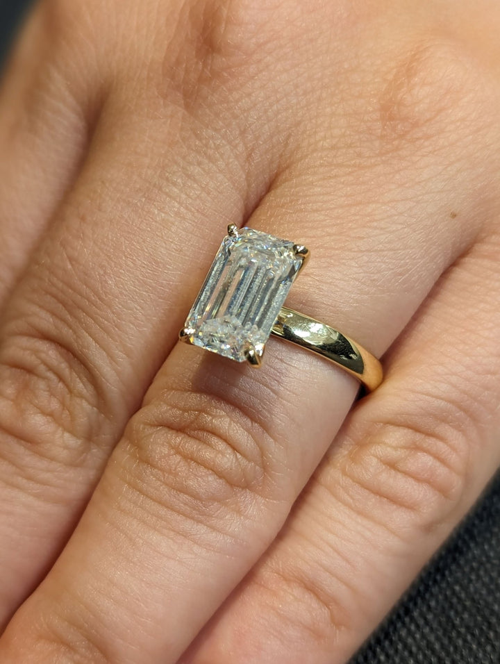 Side angle of emerald solitaire diamond engagement ring