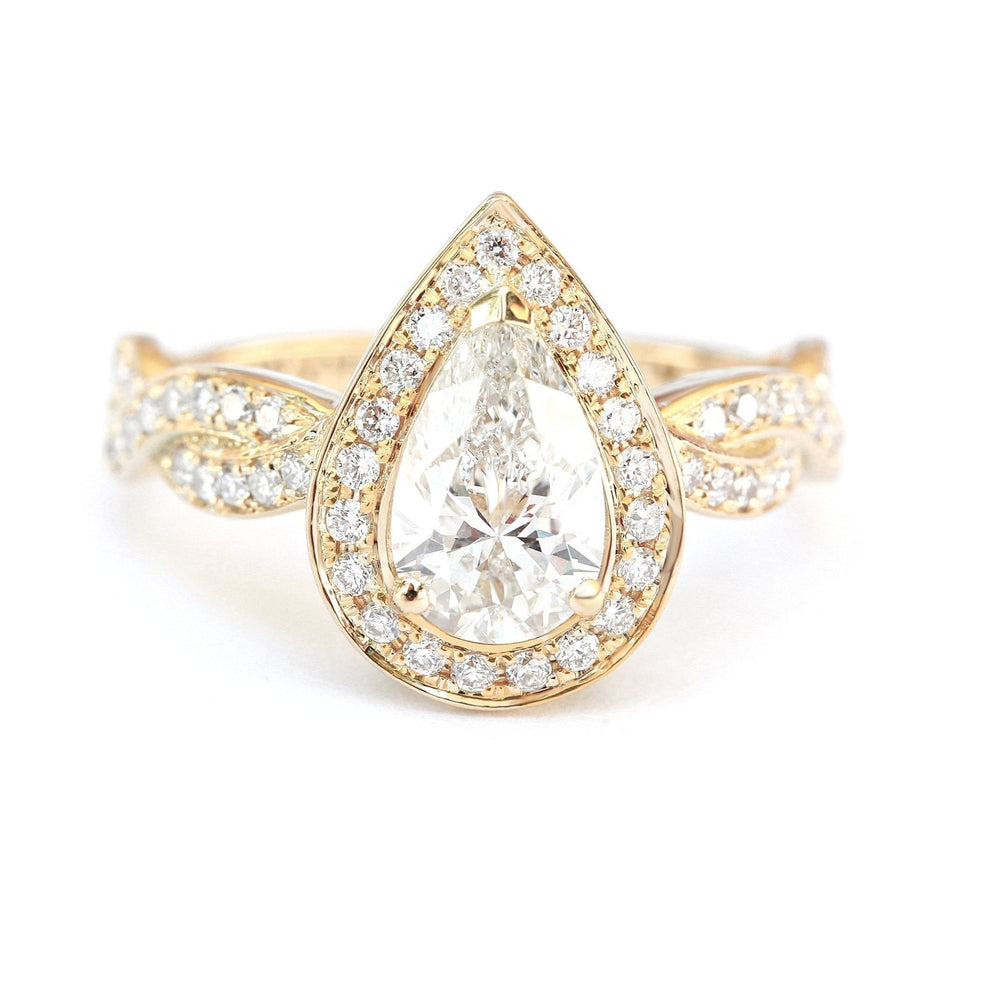 Close-up of pear cut center diamond in pave engagement ring
