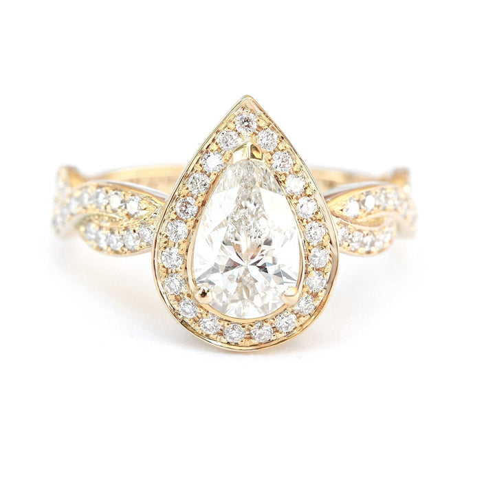 Close-up of pear cut center diamond in pave engagement ring