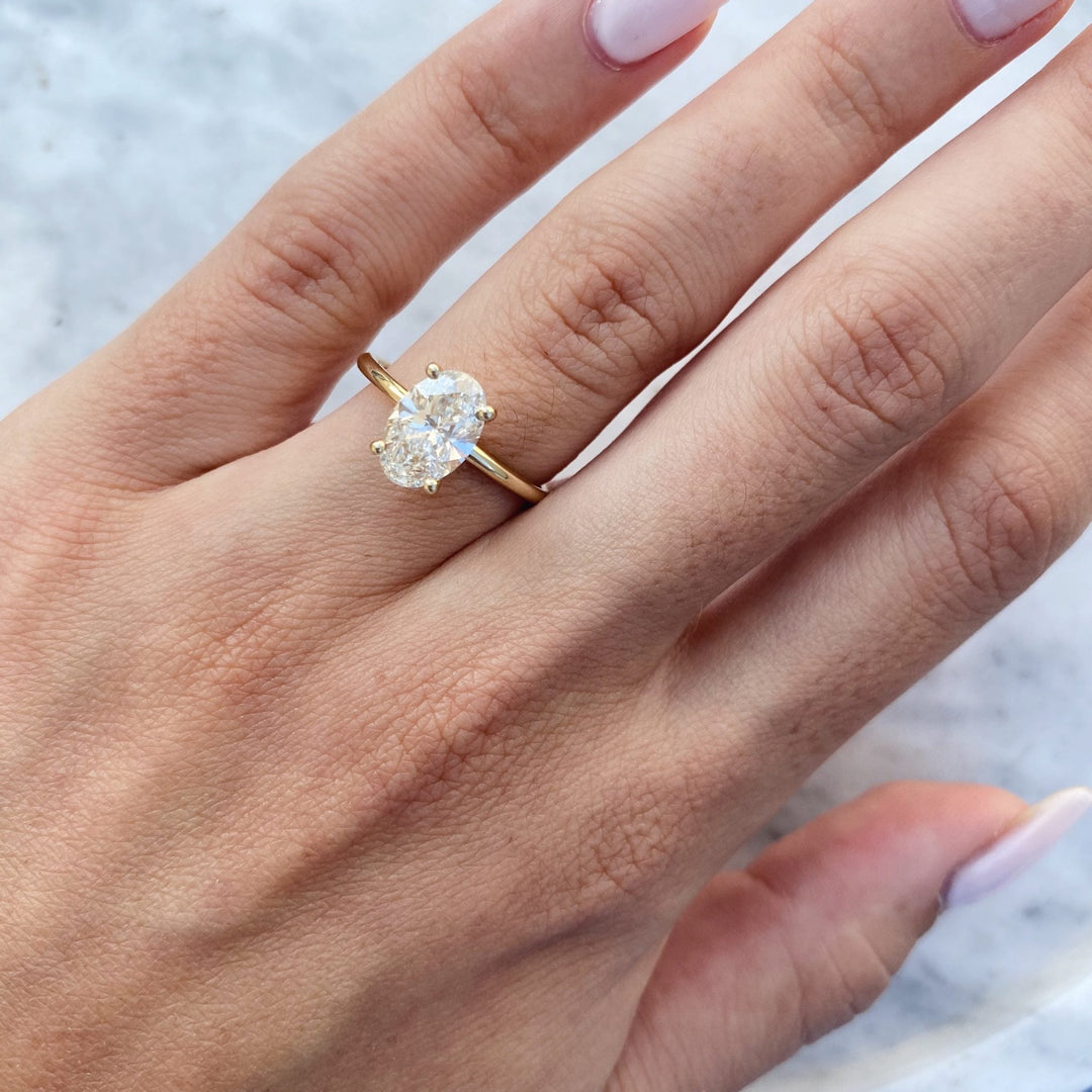Lifestyle shot of oval solitaire diamond ring on hand