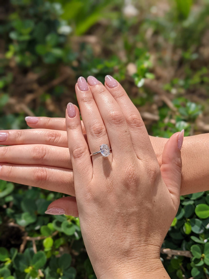 Lifestyle shot of oval solitaire diamond ring on hand