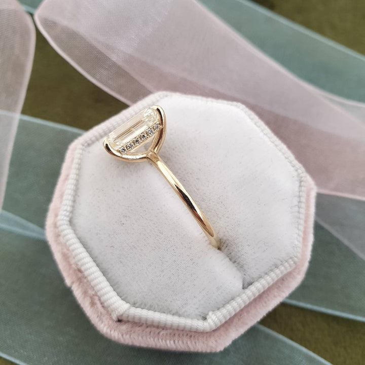 Profile view of emerald cut hidden halo engagement ring band