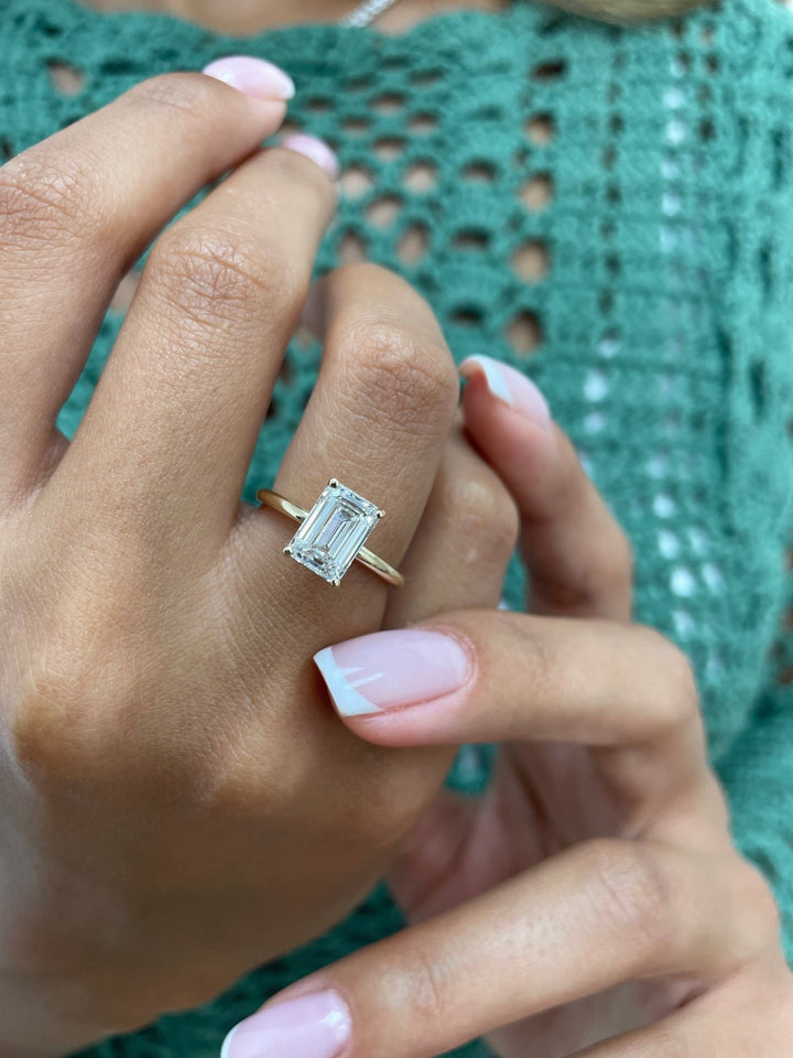 Side angle of emerald solitaire diamond engagement ring