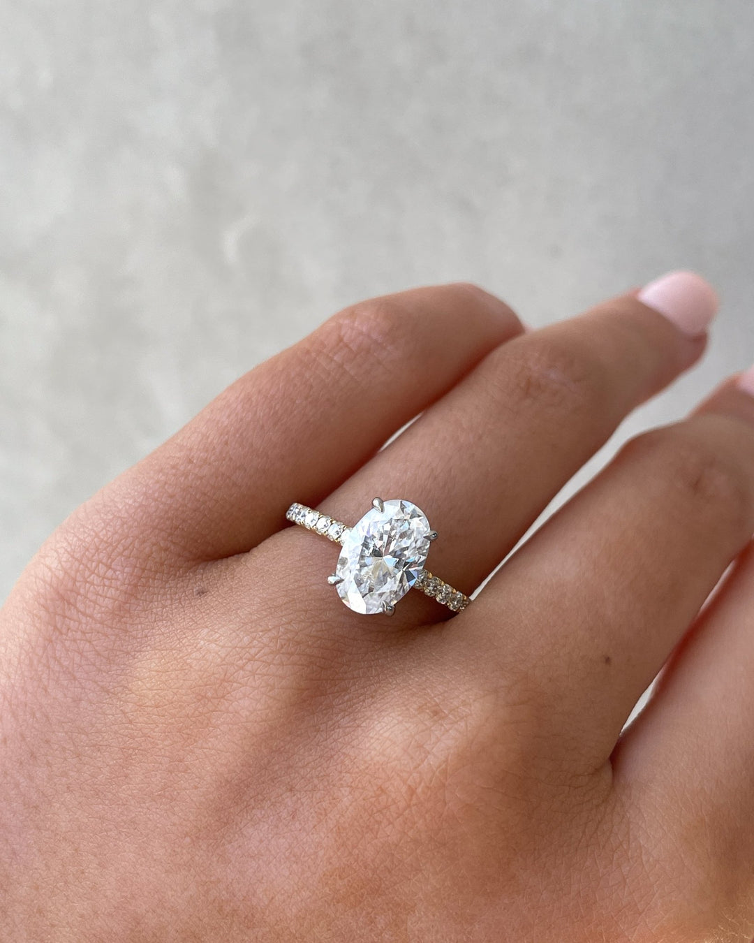 Oval hidden halo engagement ring finished in polished solid gold