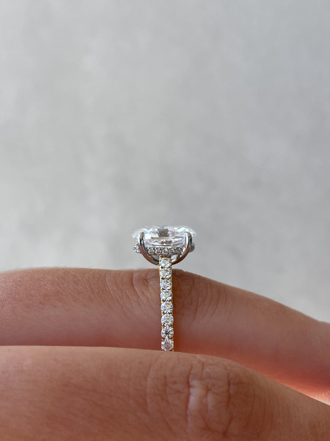 Oval hidden halo engagement ring photographed in natural light