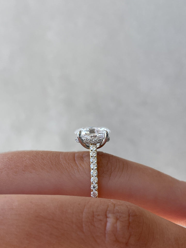 Oval hidden halo engagement ring photographed in natural light