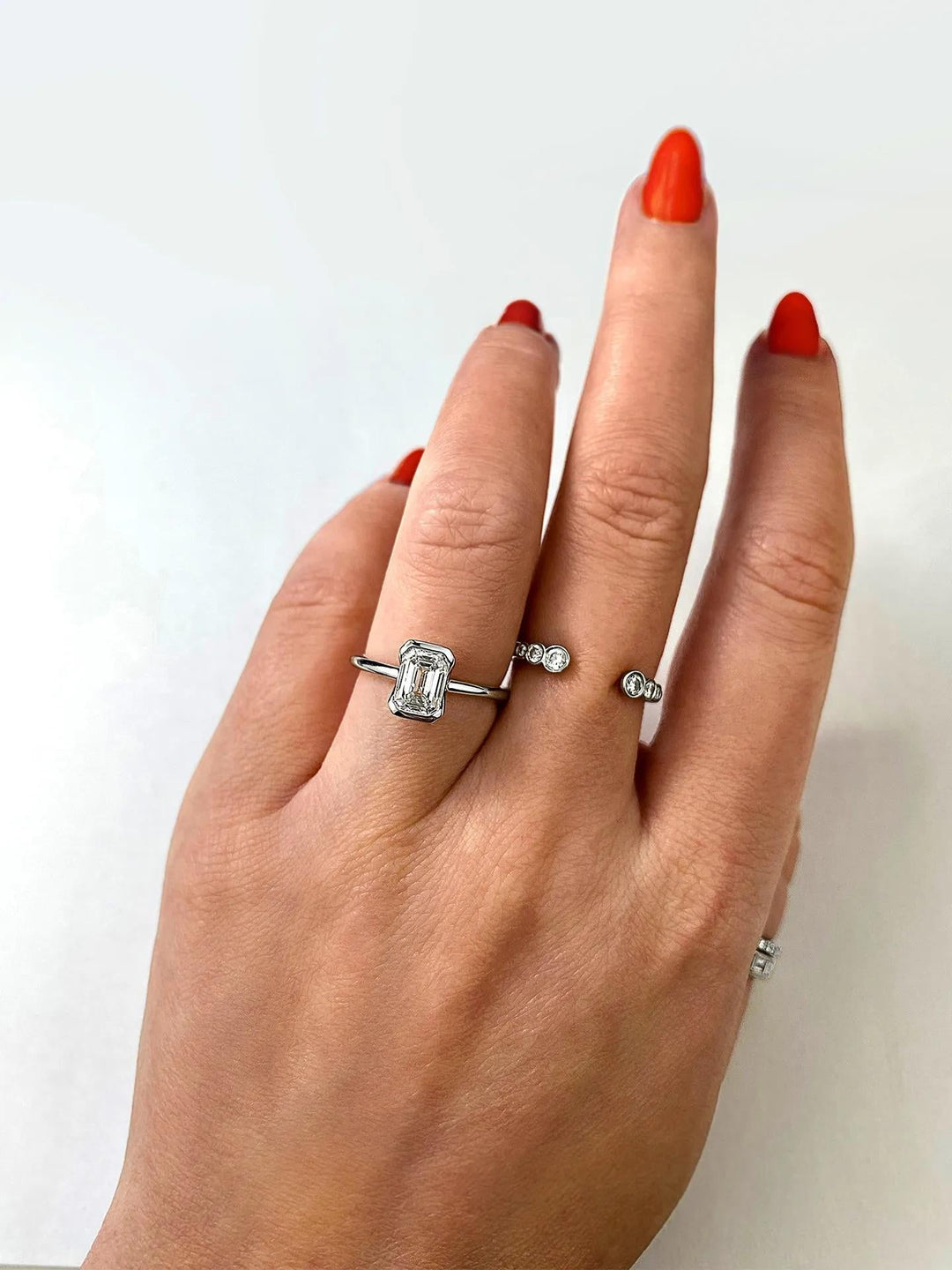 Lifestyle shot of emerald solitaire diamond ring on hand