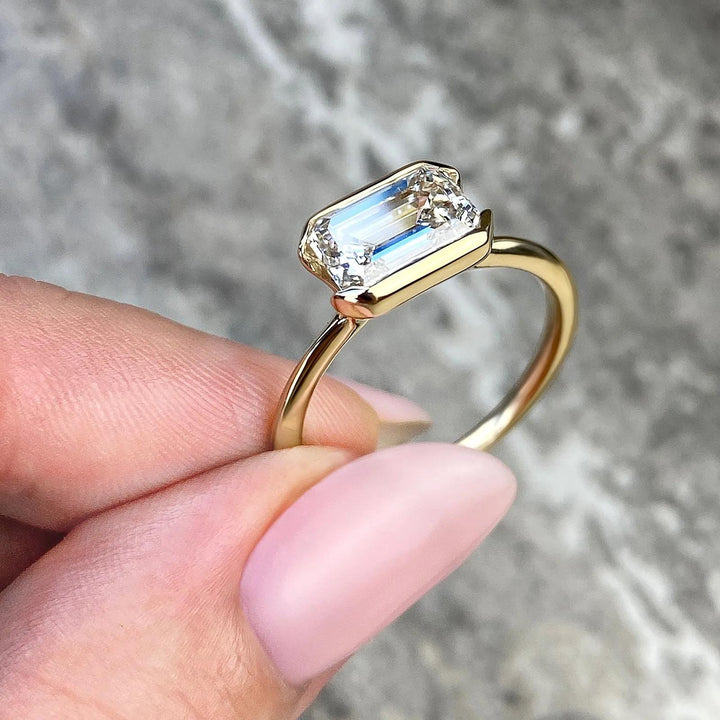 Emerald solitaire engagement ring viewed from the side