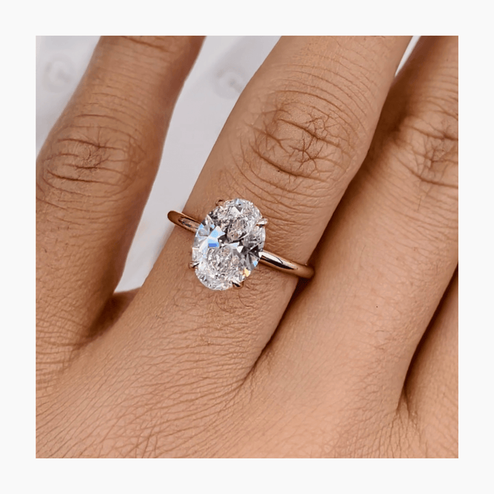 Oval hidden halo engagement ring finished in polished solid gold