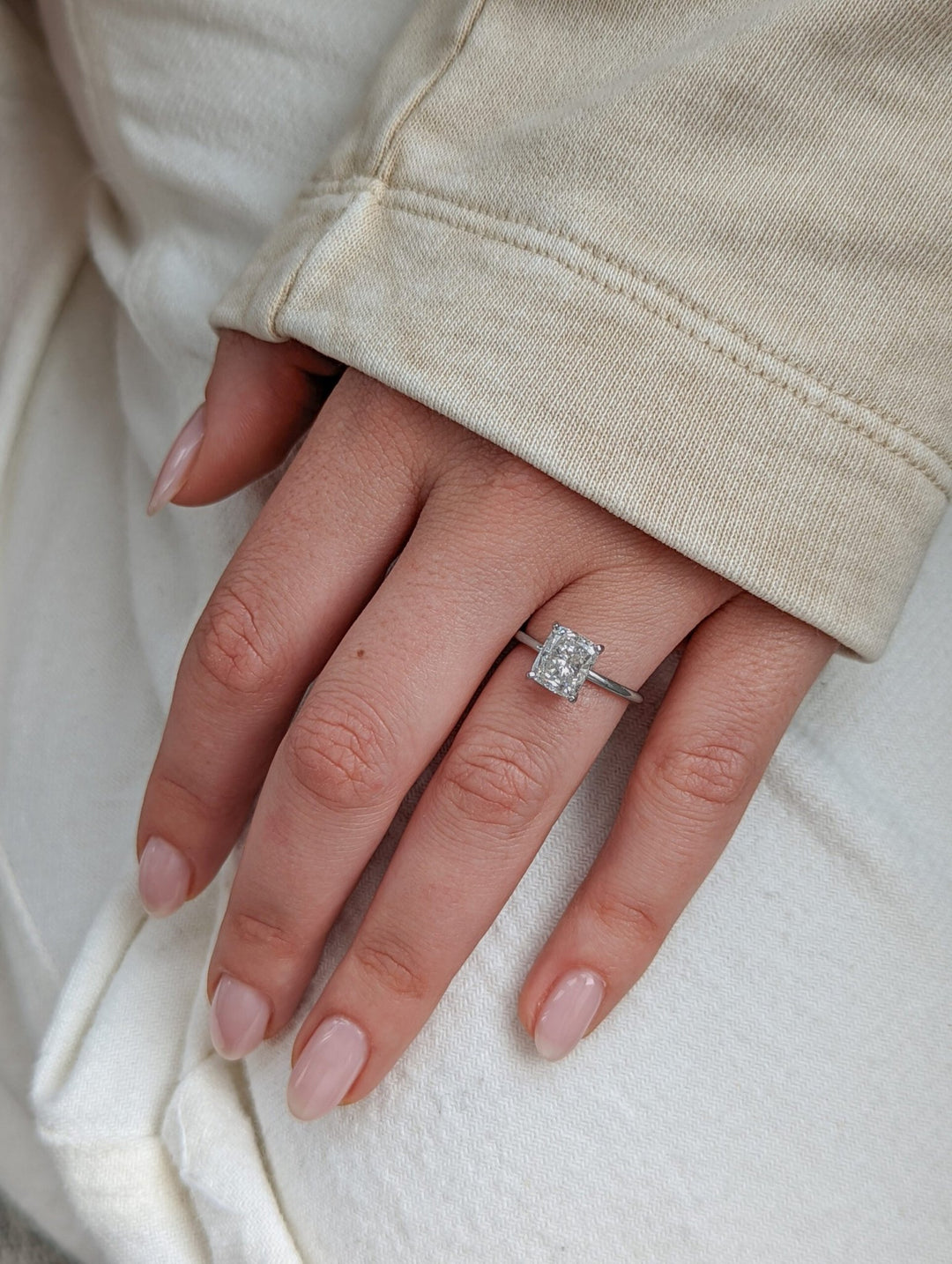 Cushion solitaire diamond ring displayed on jewelry stand