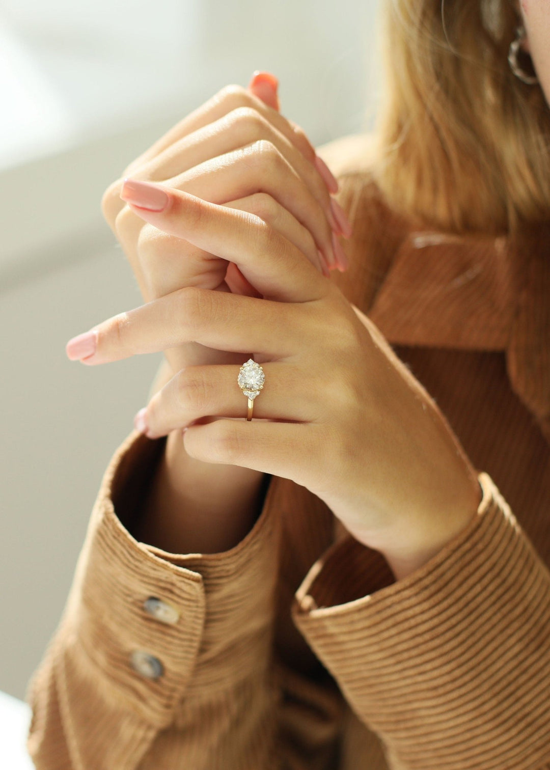 Round cut cluster engagement ring shown in real-life wear