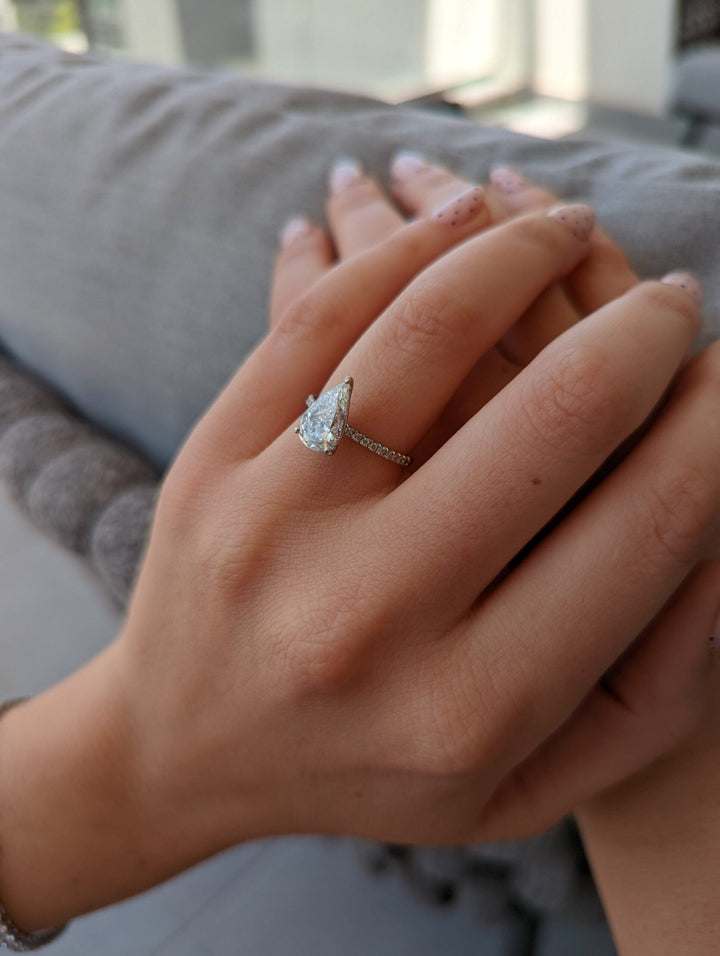 Detailed close-up of pear pave diamond engagement ring