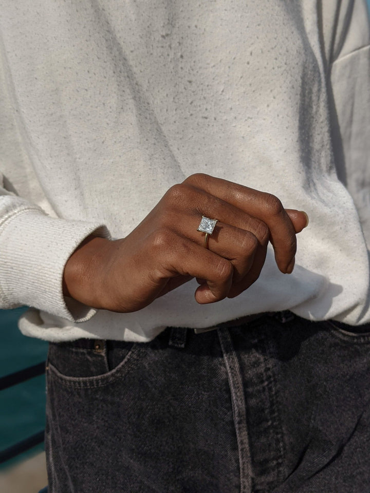 Lifestyle shot of princess solitaire diamond ring on hand
