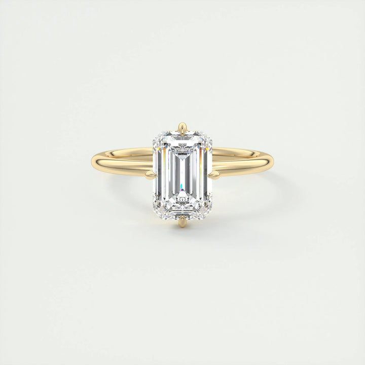 Emerald solitaire diamond ring displayed on jewelry stand