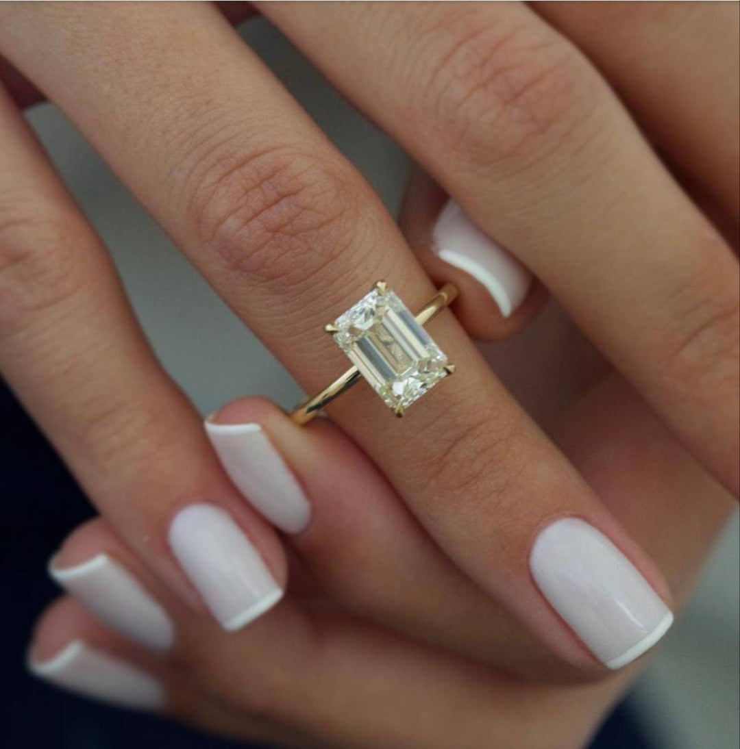 Side angle of emerald hidden halo diamond engagement ring