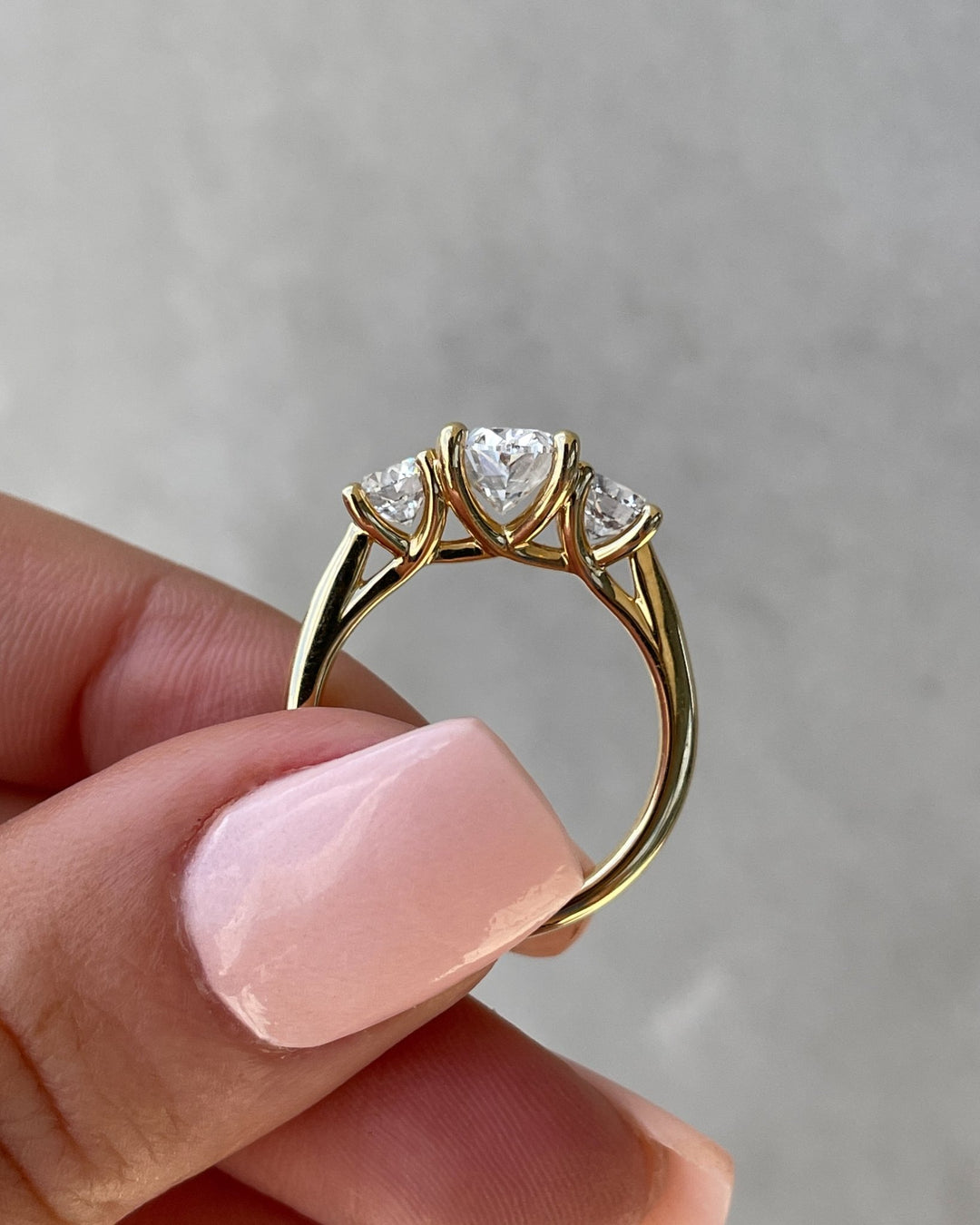 Close-up of oval cut center diamond in three stone engagement ring