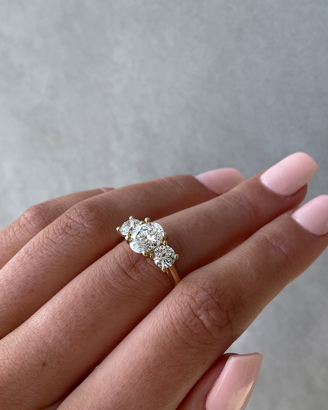 Macro shot of oval cut diamond facets in three stone ring setting