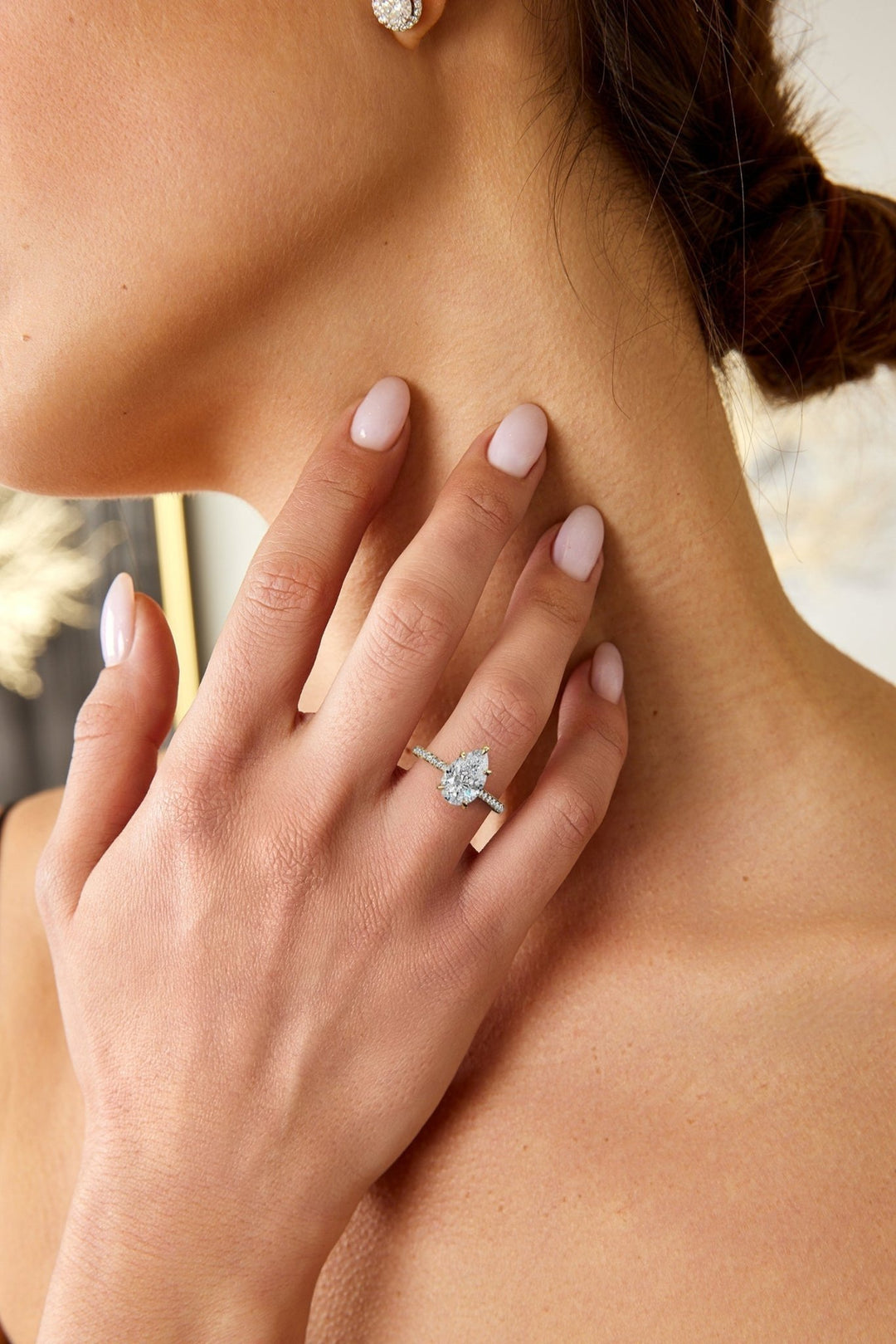 Pear cut hidden halo engagement ring shown in real-life wear