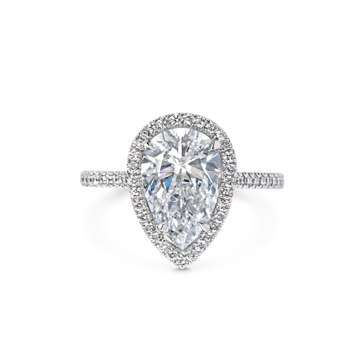 Close-up of pear cut center diamond in pave engagement ring