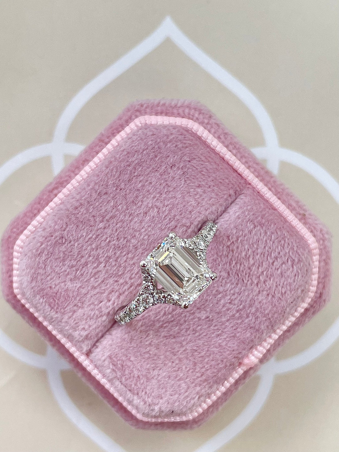 Lifestyle shot of emerald split shank diamond ring on hand