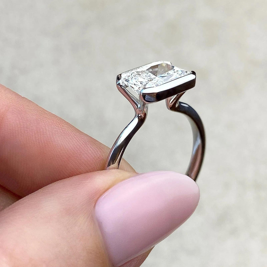 Side angle of emerald solitaire diamond engagement ring