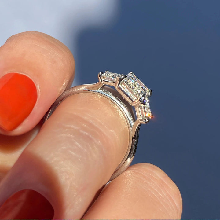 Emerald three stone ring set with an IGI graded diamond
