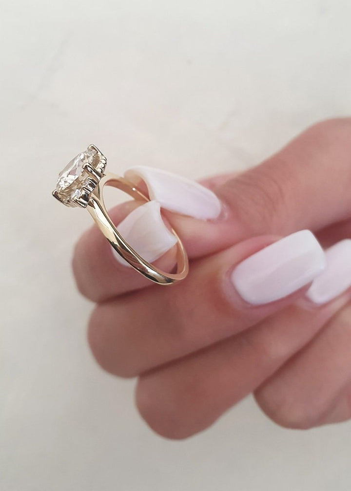 Round cluster engagement ring shown on hand for true-to-life sizing