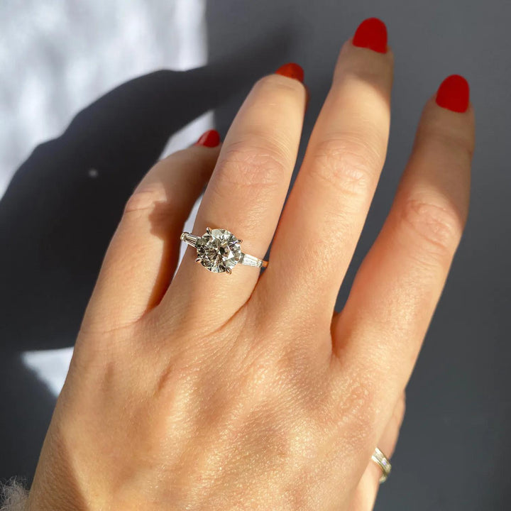 Round three stone engagement ring photographed in natural light