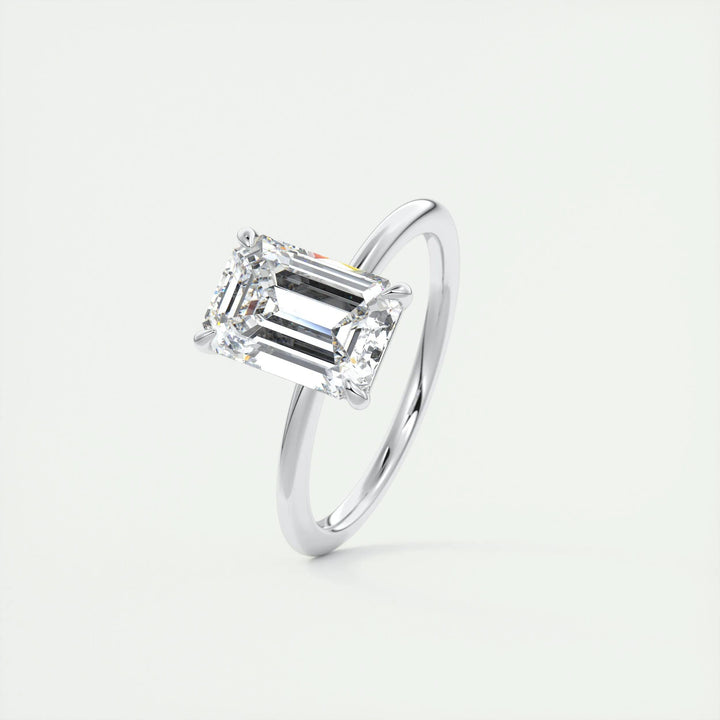 Emerald solitaire diamond ring displayed on jewelry stand