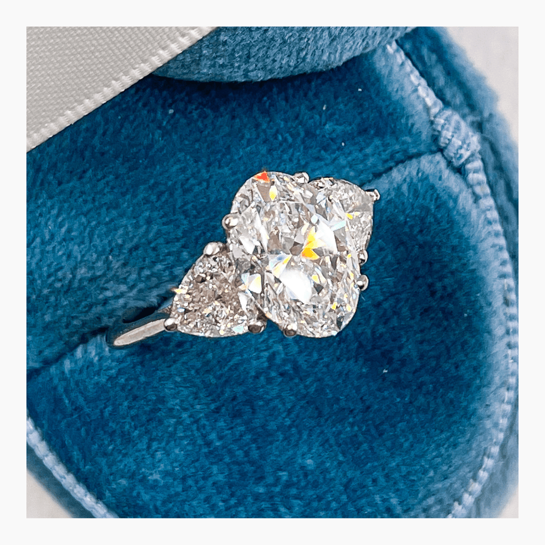 Oval three stone ring set with an IGI graded diamond