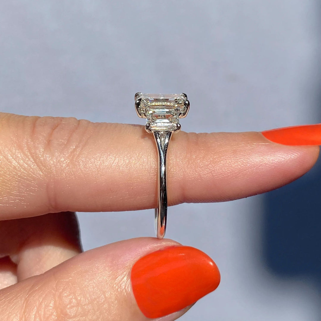 Emerald three stone diamond engagement ring available in multiple metals