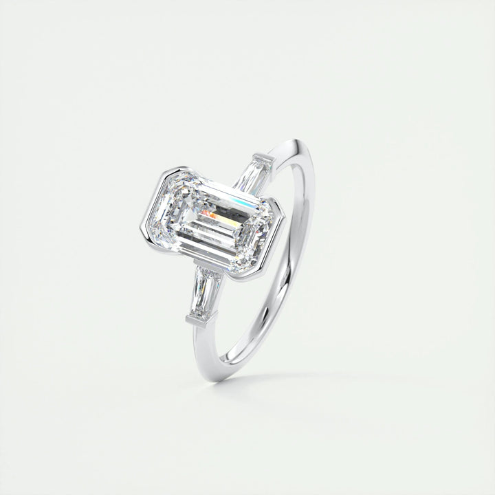 Emerald three stone diamond ring displayed on jewelry stand