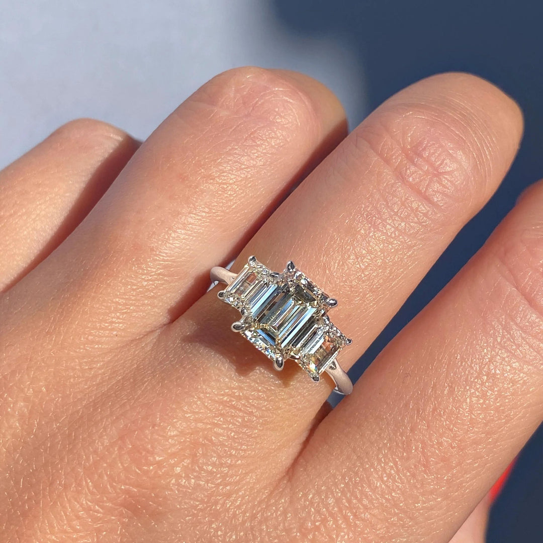 Emerald cut engagement ring shown with authenticity certificate