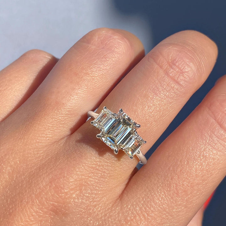 Emerald cut engagement ring shown with authenticity certificate